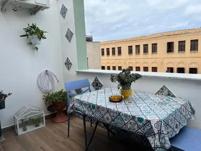 a balcony with a table and chairs and a building at M'AMA apartment 2 in Ficarazzi