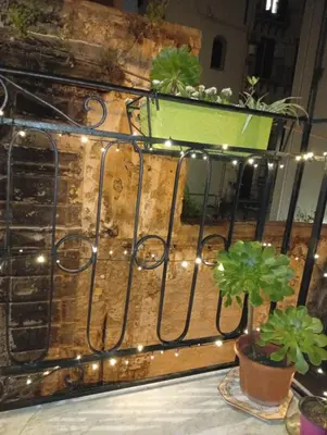 a wrought iron fence with lights and a potted plant at Le due Marie in Palermo
