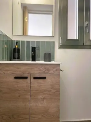a kitchen with a wooden cabinet and a mirror at Le due Marie in Palermo