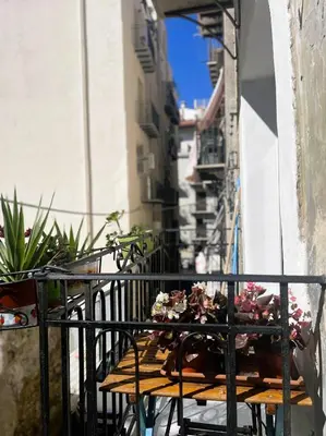 a wooden table with flowers on a balcony at Le due Marie in Palermo