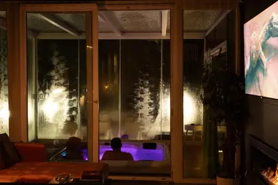 two people sitting in front of a window with purple lights at Spera Luxury in Monreale