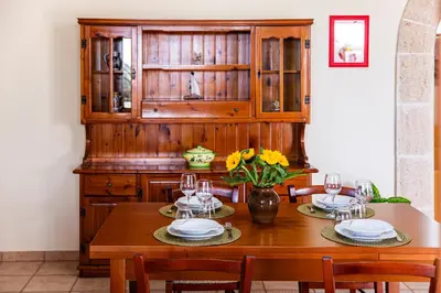 a dining room table with two plates and a vase of flowers at Exclusive Palm House near the beach in Alcamo