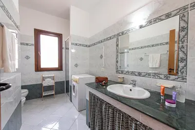 a bathroom with a sink and a mirror at Exclusive Palm House near the beach in Alcamo