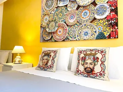 a bed with two pillows and a wall with plates at Al Politeama Rooms B&B in Palermo