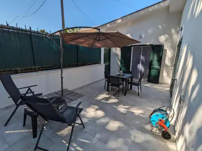 a patio with an umbrella and a table and chairs at Mondello Villetta Giusi in Mondello