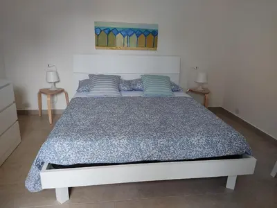 a bedroom with a bed with a blue comforter at Mondello Villetta Giusi in Mondello