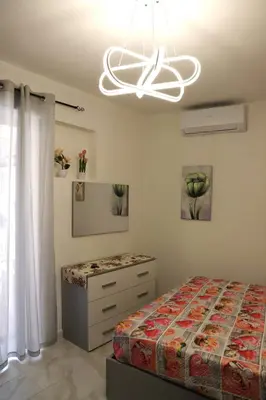 a bedroom with a bed and a chandelier at Lo scarrozzo room in Palermo