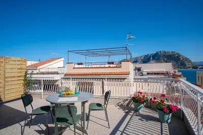a patio with a table and chairs on a balcony at Mondello SunSea in Mondello