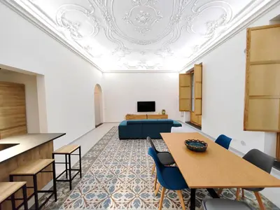 a room with a table and chairs and a couch at Ciuririvù in Palermo