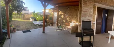 an outdoor patio with a fireplace and a couch at Casa al mare in Lascari