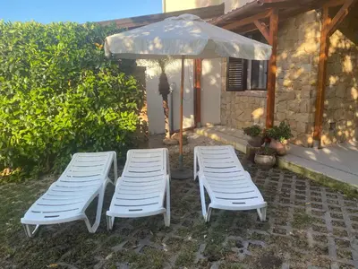 two chairs and an umbrella on a patio at Casa al mare in Lascari