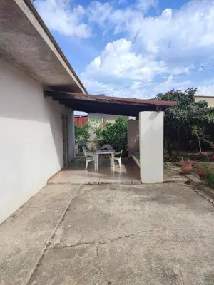 a patio with a table and chairs under a roof at Balestrate holiday home 70 Mq in Balestrate