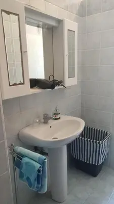 a bathroom with a white sink and a mirror at Balestrate holiday home 70 Mq in Balestrate