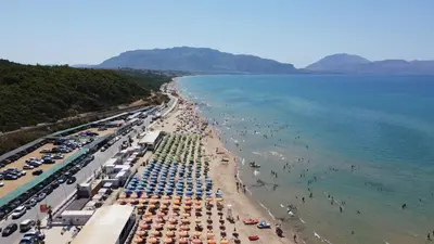 a beach with many umbrellas and people in the water at Villa Ginevra in Balestrate