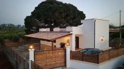 a house with a wooden fence and a car on it at Villa Ginevra in Balestrate