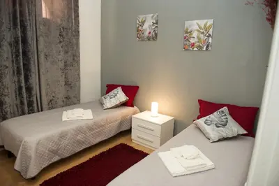 two beds in a small room with a lamp on a night stand at Casa Vacanze Ines in Carini