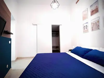 a bedroom with a blue bed and a tv at Casa di DaFe-Casa Vacanze in Castellammare del Golfo