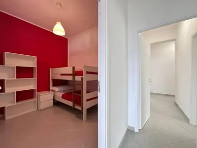a bedroom with red walls and a bunk bed at Brezza Marina Apartment, 50 mt dalla spiaggia in Alcamo