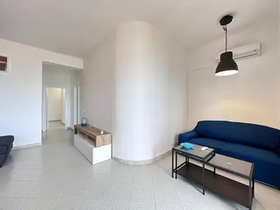 a living room with a blue couch and a table at Brezza Marina Apartment, 50 mt dalla spiaggia in Alcamo