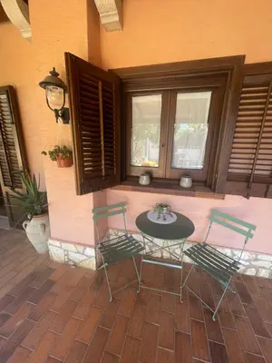 a patio with a table and chairs and windows at Baglio Sammartano ROOM&TOUR in Castelluzzo