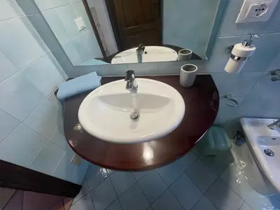 a bathroom with a wooden sink and a mirror at Baglio Sammartano ROOM&TOUR in Castelluzzo