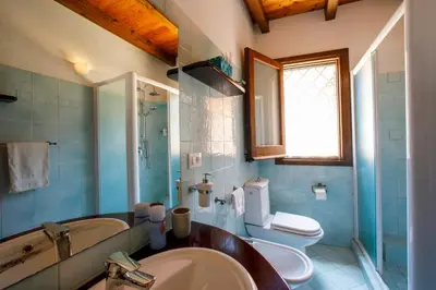 a bathroom with a sink and a toilet and a mirror at Baglio Sammartano ROOM&TOUR in Castelluzzo