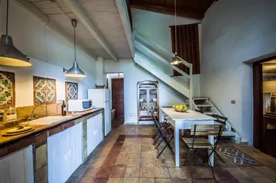 a kitchen with a table and some chairs in it at Casa Strelizie in Terrasini