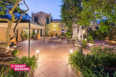 a courtyard with a fountain in the middle of a house at Villa Ammirata Mondello by Wonderful Italy in Mondello