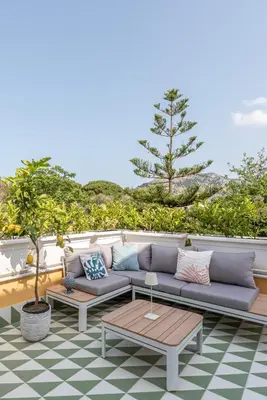 a patio with a couch and a table at Villa Ammirata Mondello by Wonderful Italy in Mondello