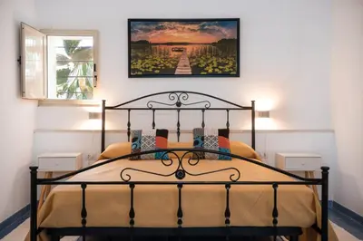 a bedroom with a bed with a picture on the wall at GuestHost - La Giara - Villa with Swimming Pool and Parking in Castellammare del Golfo
