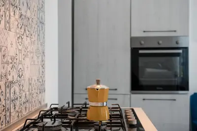a kitchen with a stove with a yellow appliance on it at GuestHost - La Giara - Villa with Swimming Pool and Parking in Castellammare del Golfo
