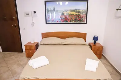 a bedroom with a bed with a picture on the wall at Politeama guest house Palermo Pomelia in Palermo