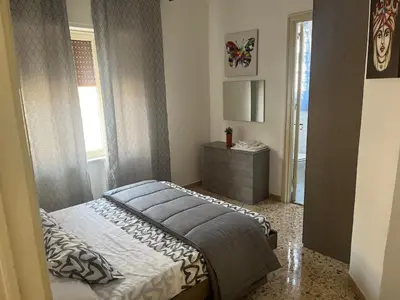 a bedroom with a bed and a dresser and a window at Costanza House in Palermo