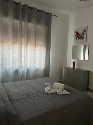 two swans made out of towels on a bed at Costanza House in Palermo