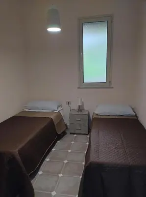 a bedroom with two beds and a window at Home SG jato in San Giuseppe Jato