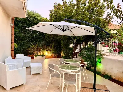 a patio with a table and chairs and an umbrella at Villa La Palmetta a San Vito lo capo in San Vito lo Capo