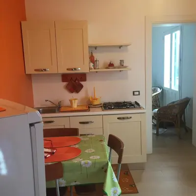 a kitchen with a table and a stove top oven at Villa La Palmetta a San Vito lo capo in San Vito lo Capo