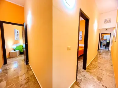 a hallway with two mirrors and a room with a bed at Orange House in Isola delle Femmine
