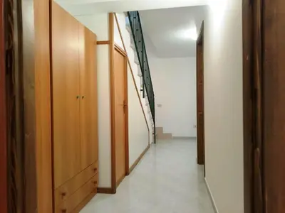 a hallway with wooden cabinets and a stairway at Sanvitotour - Appartamento Amaca in San Vito lo Capo