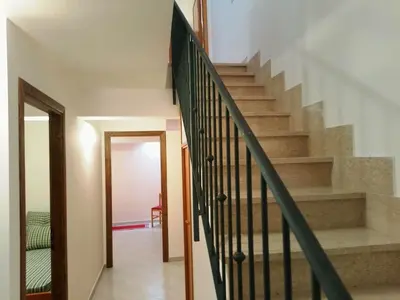 a staircase with a green railing in a house at Sanvitotour - Appartamento Amaca in San Vito lo Capo