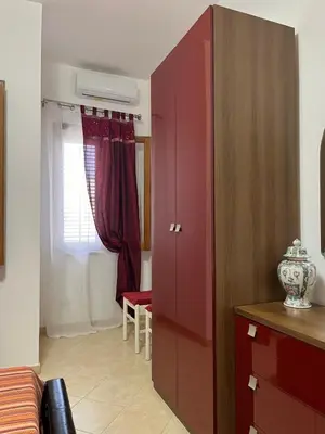 a large red cabinet in a room with a window at Casa Finuzza in San Vito lo Capo