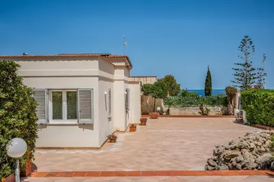 a villa with a courtyard in front of a house at Villa Spada con ampi spazi esterni in San Vito lo Capo