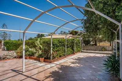 a greenhouse in a garden with plants at Villa Spada con ampi spazi esterni in San Vito lo Capo