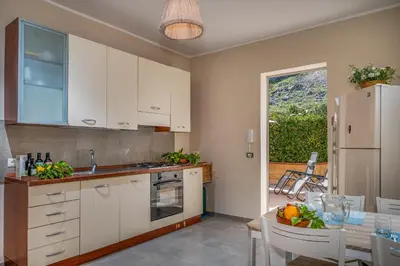 a kitchen and dining room with a table and a refrigerator at Villa Spada con ampi spazi esterni in San Vito lo Capo