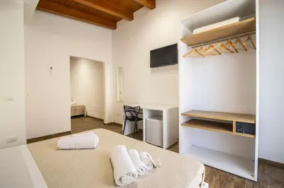 a room with a bed and a desk with towels at Quattro Canti in Carini