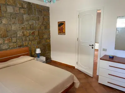 a bedroom with a bed and a brick wall at PANORAMIC VIEW - Sabrina's house in Altavilla Milicia