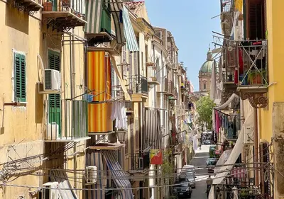 an alley with buildings and cars on a street at Solemar Sicilia - Casa Enrica in Palermo