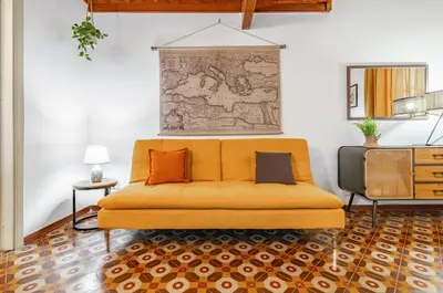 a yellow couch in a living room with a map on the wall at GuestHost - The Traveller's House - Palermo Station Apartments in Palermo