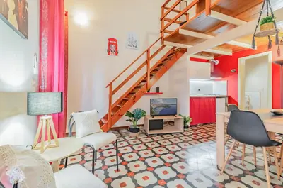 a living room with a staircase and a table and chairs at GuestHost - The Traveller's House - Palermo Station Apartments in Palermo