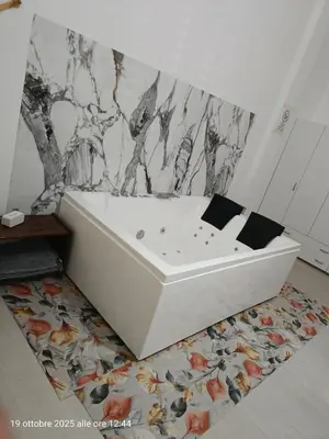 a white bath tub sitting on a rug in a bathroom at casa colombo in Balestrate